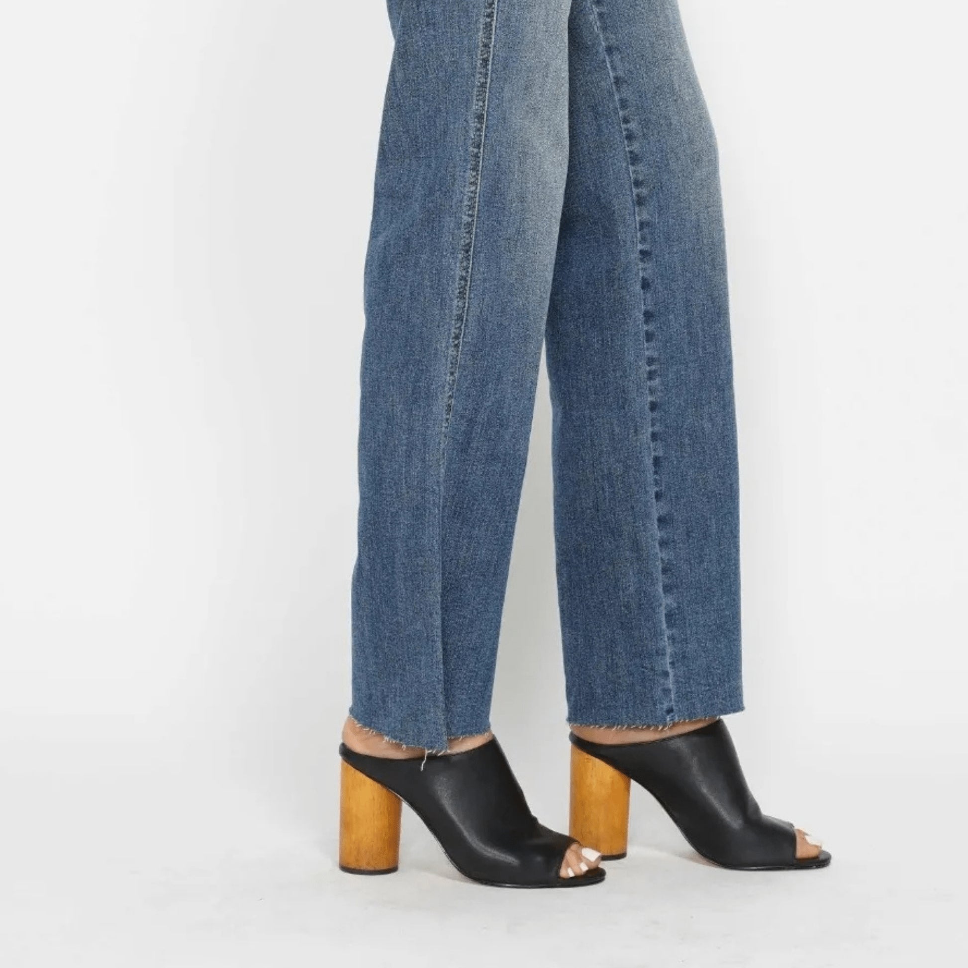 Lifestyle shot of a woman wearing tummy control straight jeans for a casual-chic look.