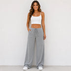 Woman wearing light gray drawstring straight-leg pants with elastic waist and pockets