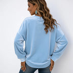 Back view of the women's light blue long sleeve velvet solid color top with a relaxed oversized fit.