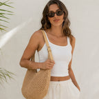 Women's natural mesh crochet shoulder bag with adjustable faux leather strap, styled on a model for a casual beach and summer outfit.
