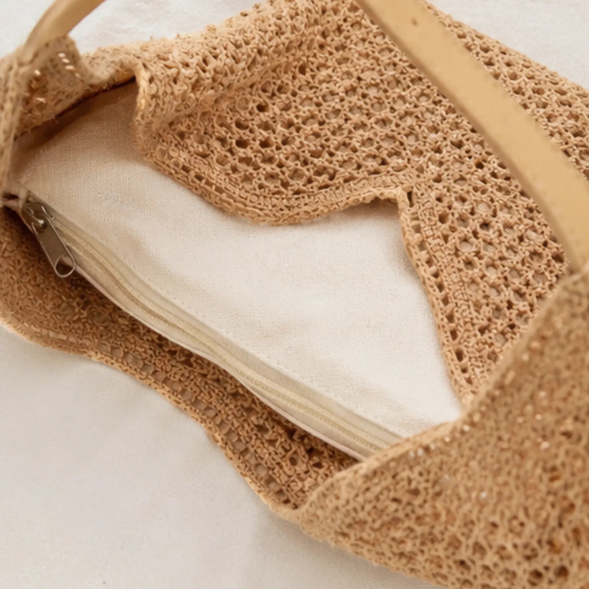 Close-up of the natural mesh crochet shoulder bag showing the removable zippered inner pouch and spacious woven interior.