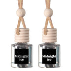 Two small reed diffuser bottles with clear glass bodies, beige wooden stoppers, and cream hanging cords, each labeled 'Midnight Ice' on a black front label, shown on a white background.
