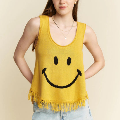 Close-up of the bold black smiley face graphic and boho fringe hem.