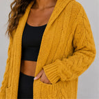 Close-up of yellow cable knit cardigan showing textured knit pattern, sleeve and pocket
