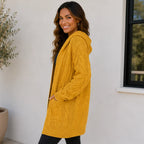 Side view of woman wearing a yellow oversized cable knit open-front cardigan