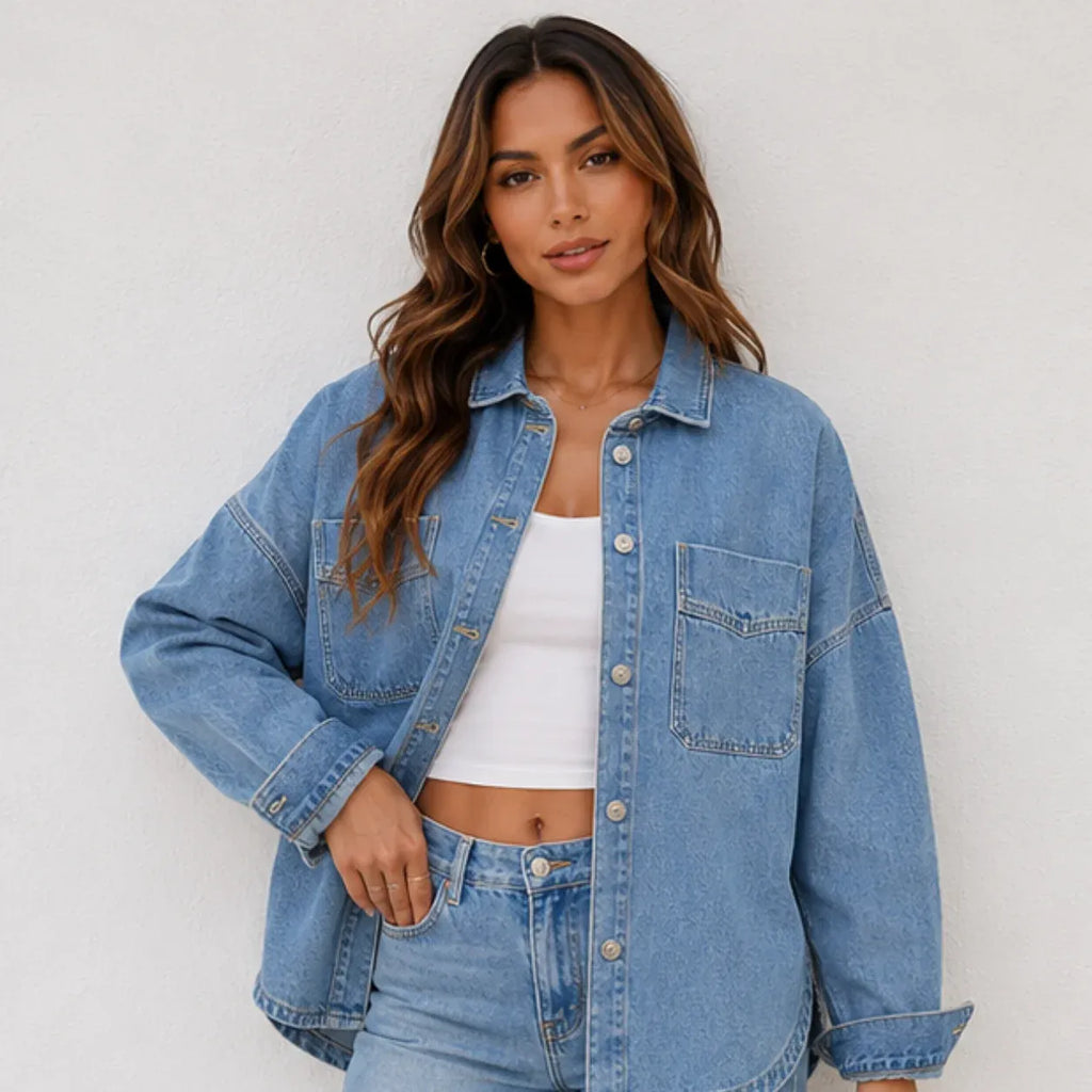 Women's oversized blue denim shirt jacket front view featuring a relaxed fit, button-front closure, and chest pockets.