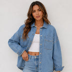 Women's oversized blue denim shirt jacket front view featuring a relaxed fit, button-front closure, and chest pockets.