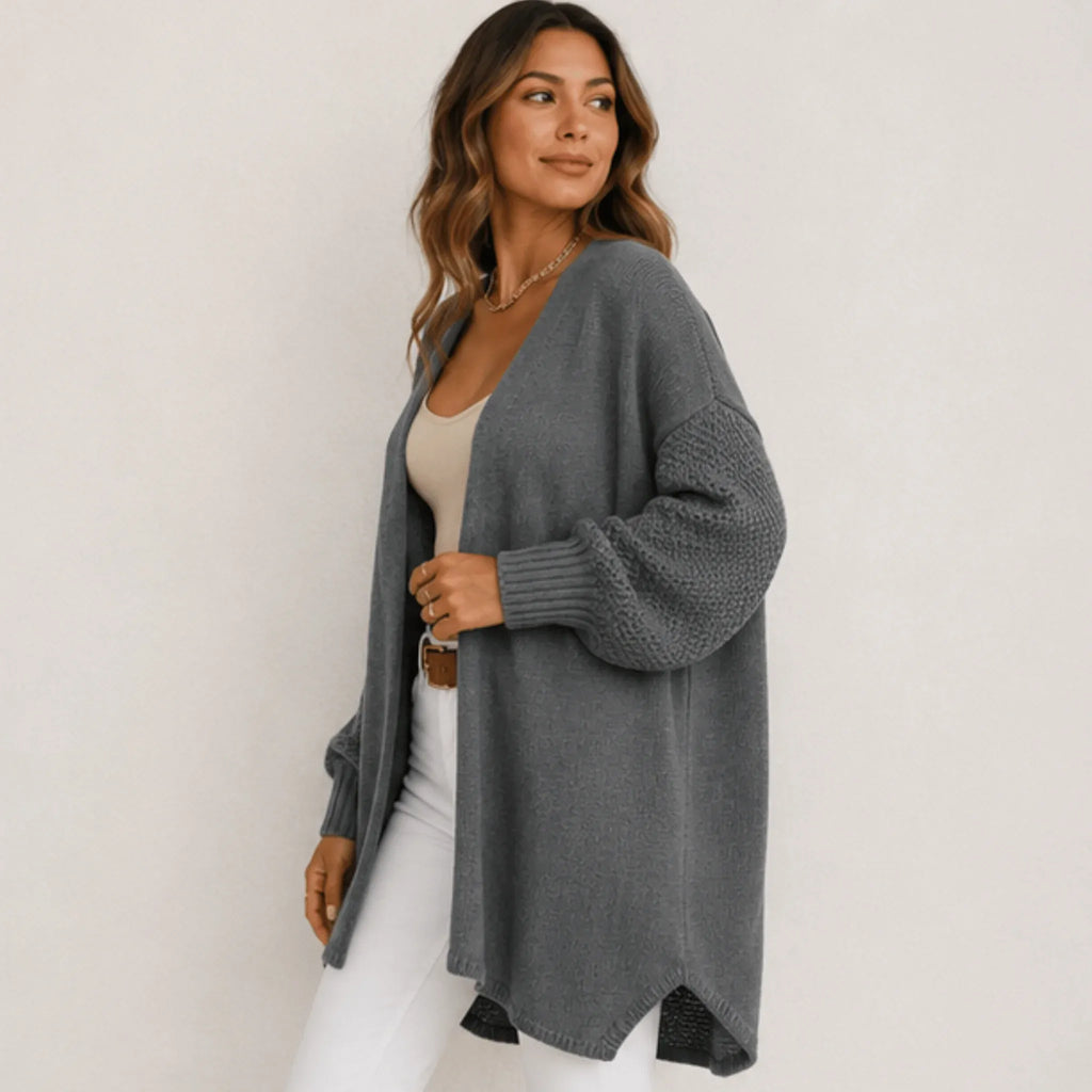 Side view of women's gray oversized open front long cardigan with an open front, longline silhouette, textured sleeves, and ribbed cuffs.