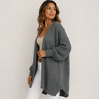 Side view of women's gray oversized open front long cardigan with an open front, longline silhouette, textured sleeves, and ribbed cuffs.