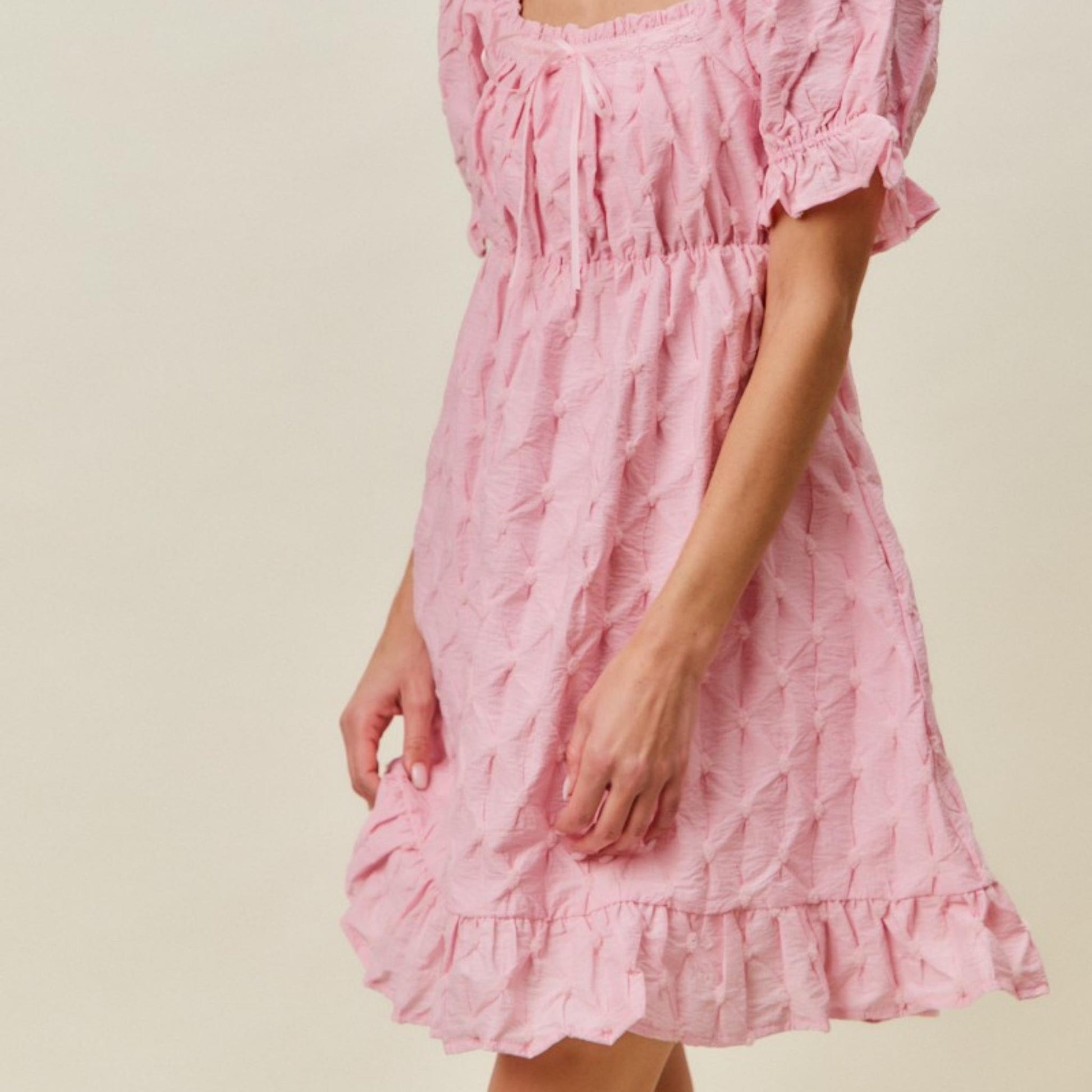 Side profile of the SO ME pink texture woven mini dress highlighting the ruffled hem.