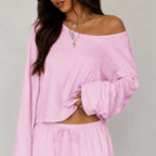 Close-up of pink women's two-piece wide-leg pants set and off-shoulder long sleeve top