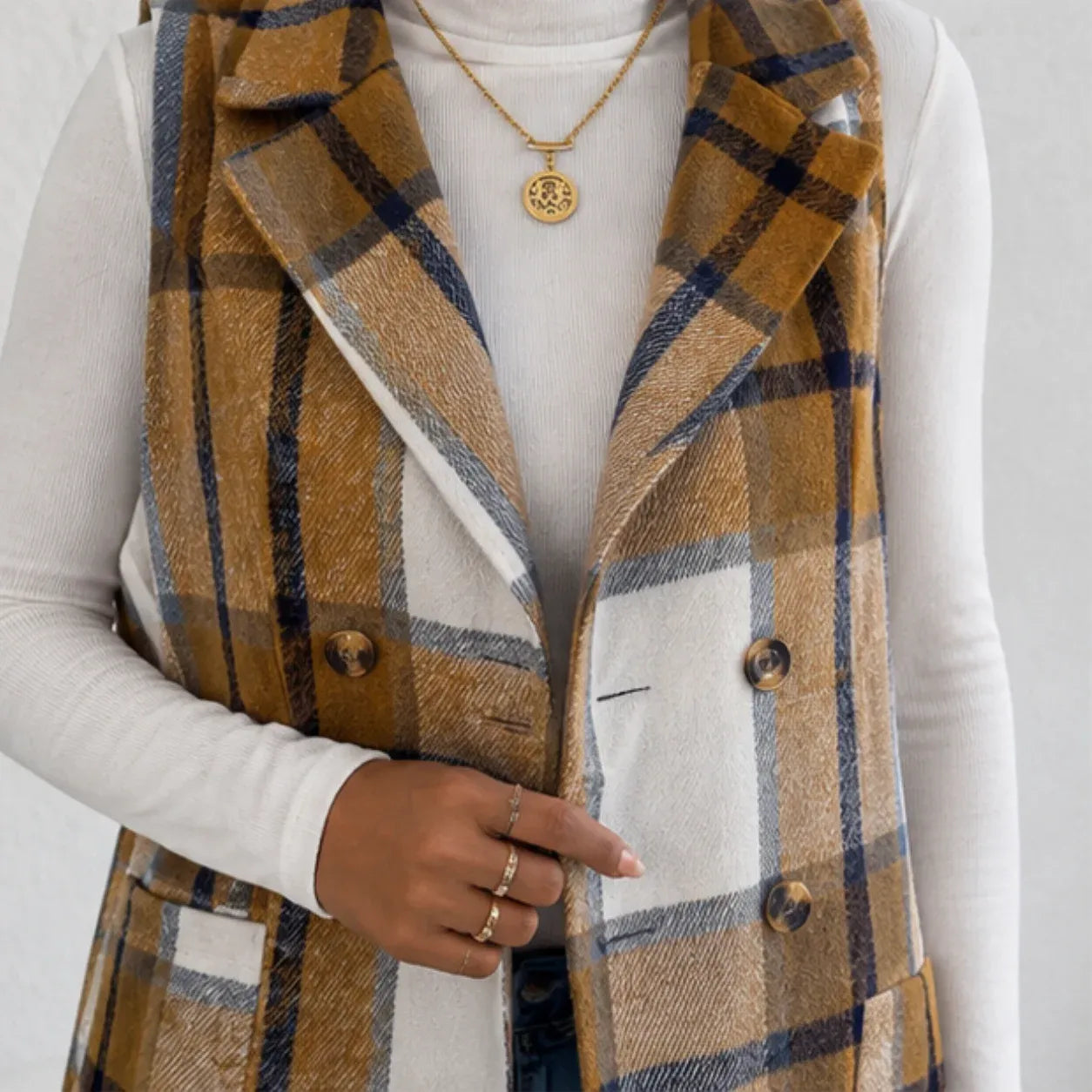 Close-up of camel plaid double-breasted long vest with button details and pockets