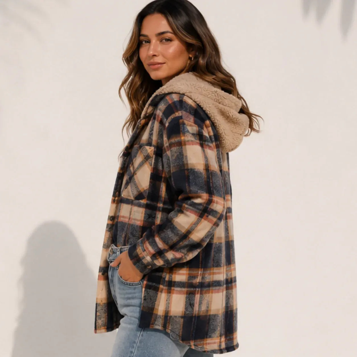 Side view of a woman wearing a brown plaid sherpa-lined hooded shacket