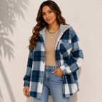 Woman wearing a teal plaid sherpa-lined hooded shacket