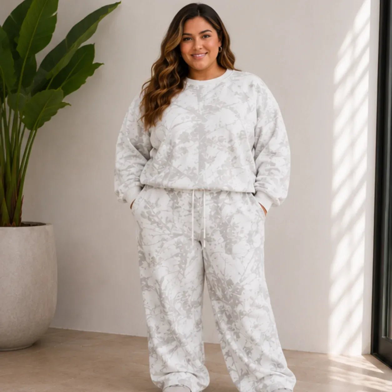 Plus size model wearing the camo maple leaf crewneck sweatshirt and sweatpants set