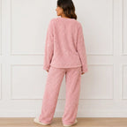 Back view of woman wearing a pink plush fleece pajama set with long sleeves and wide-leg pants