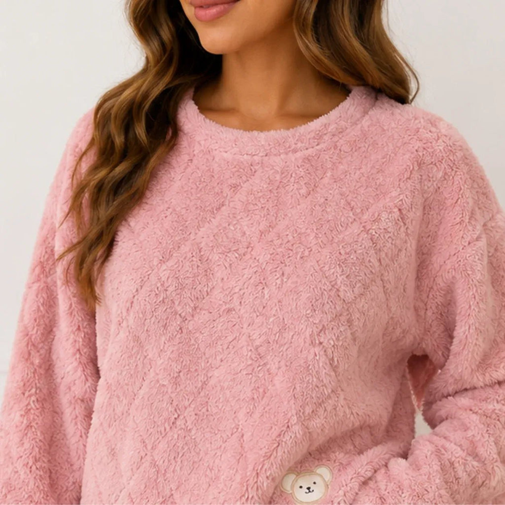 Close-up of soft pink plush fleece pajama fabric and bear detail