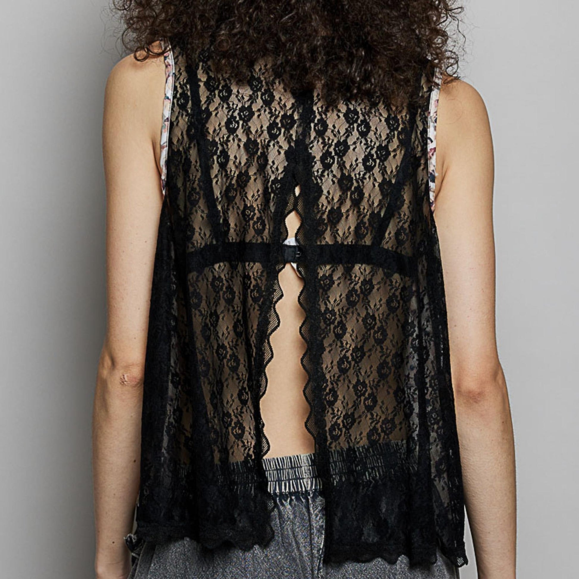 Full view of the POL black cotton sleeveless blouse with floral print.