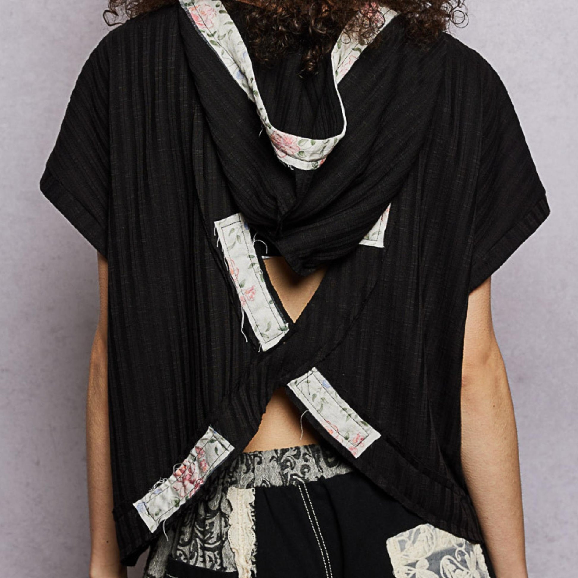 POL black short sleeve hooded top showing stylish open back — back view.