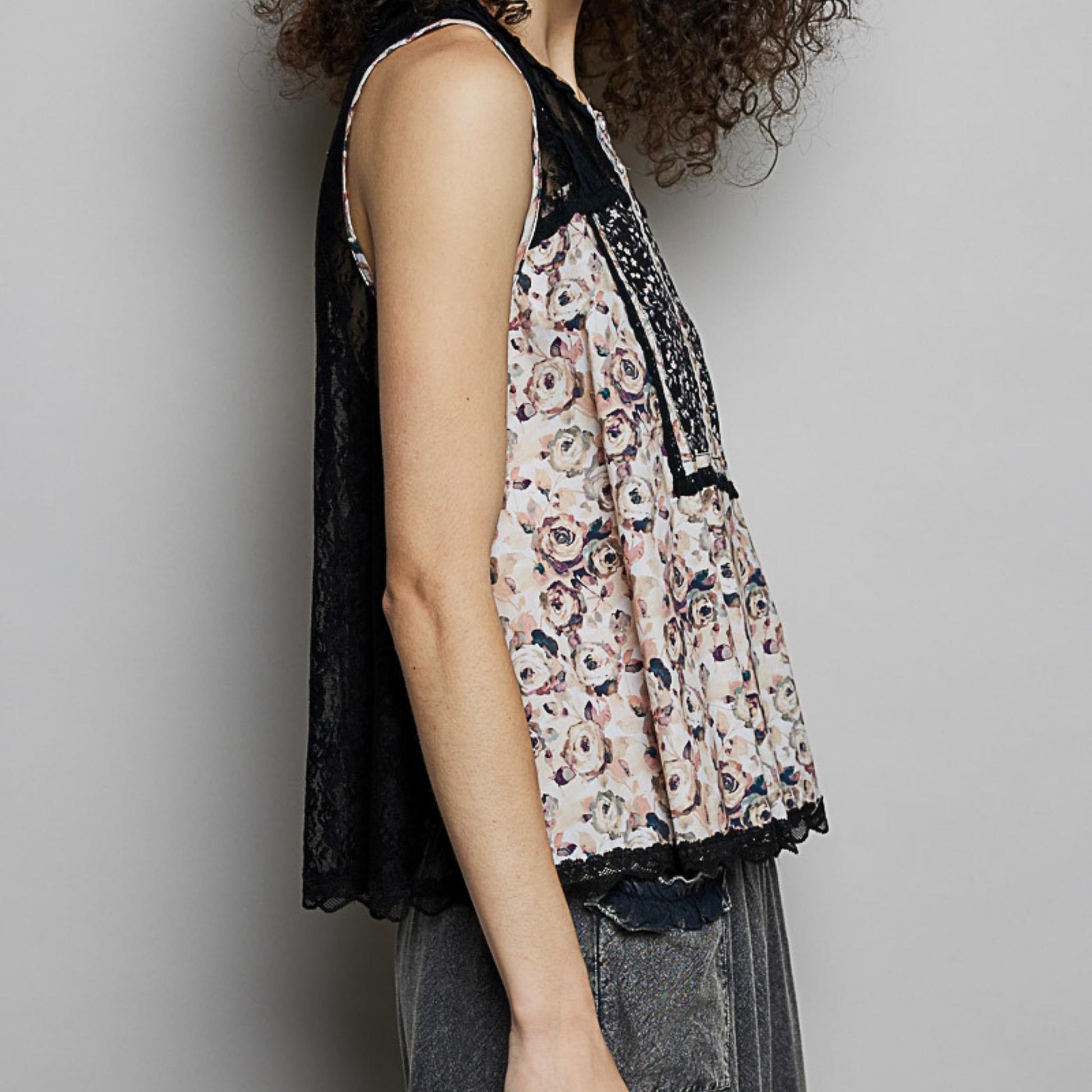 Side perspective of the black cotton blouse highlighting the lace trim details.