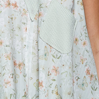 Close-up detail of the front pocket and V-neckline on the sage floral tank.