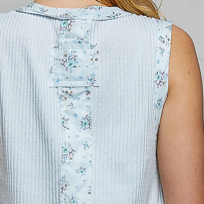 Light blue sleeveless top with floral pattern on a plain background