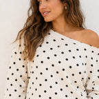 Close-up view of the white polka dot off-the-shoulder top showing the print and neckline