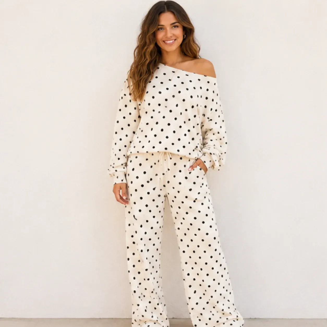Woman wearing a white polka dot off-the-shoulder top and wide-leg pants set
