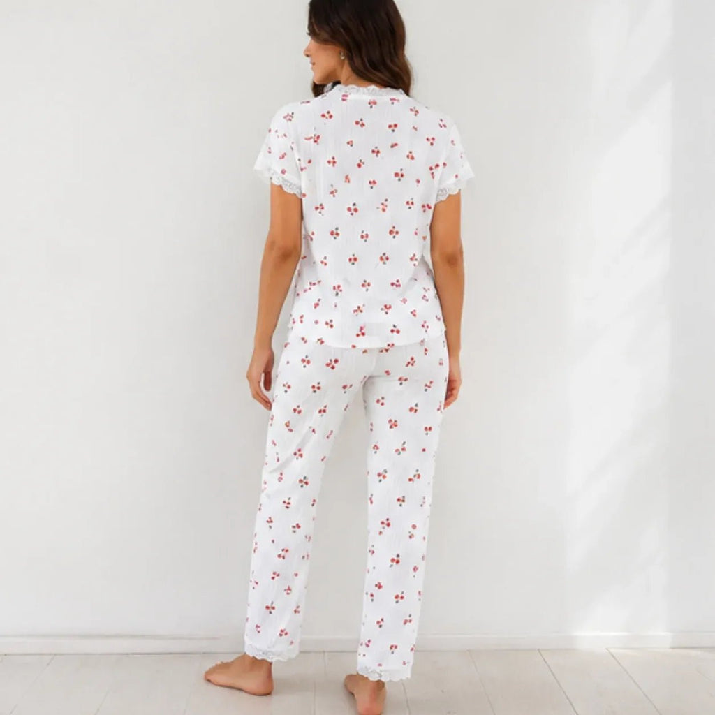Woman wearing white cherry print lace trim pajama set, back view