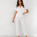 Woman wearing white cherry print lace trim pajama set, front view