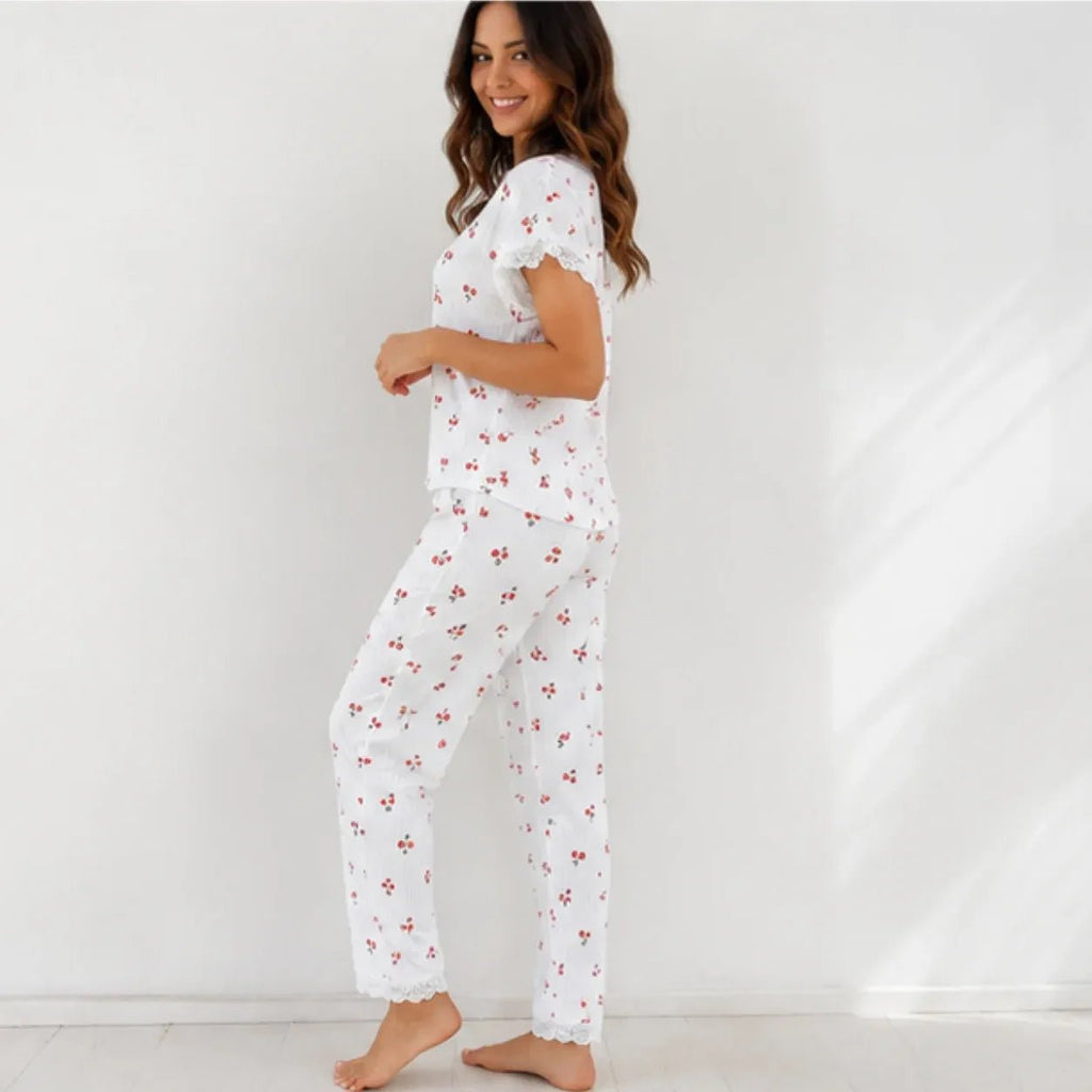 Woman wearing white cherry print lace trim pajama set, side view