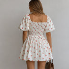 Women's Puff Sleeve Cherry Print Smocked Mini Dress back view showcasing the fully smocked back, puff sleeves, tiered bubble skirt, and all-over cherry print.