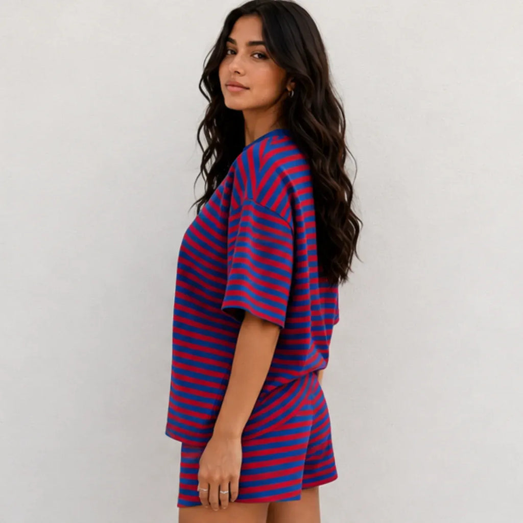 Side profile view of woman wearing red and royal blue horizontal striped short-sleeve top and shorts lounge set