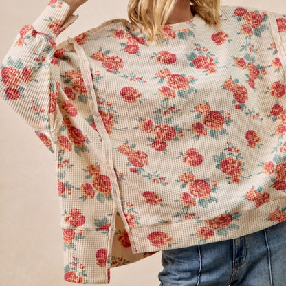 Floral-patterned fabric held by a person against a neutral background