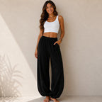 Women's relaxed wide leg cotton pants in black featuring a loose fit, elastic waistband, and full-length design.
