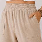 Close-up of the elastic waistband and front patch pocket detail on women's relaxed wide leg khaki cotton pants.