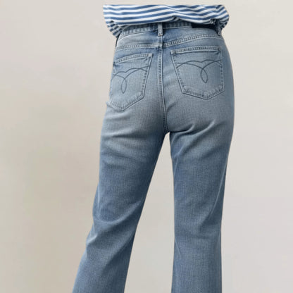 Back view of release hem bootcut jeans styled with a striped shirt.