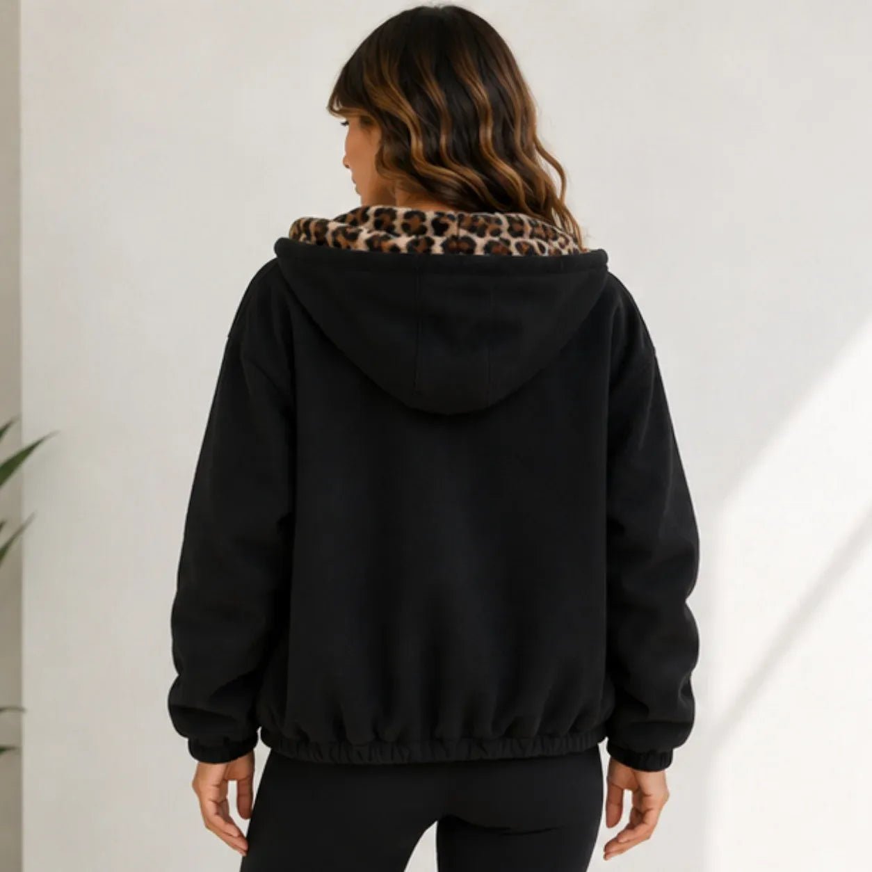 Reversible leopard hooded jacket in black, back view with leopard print hood lining