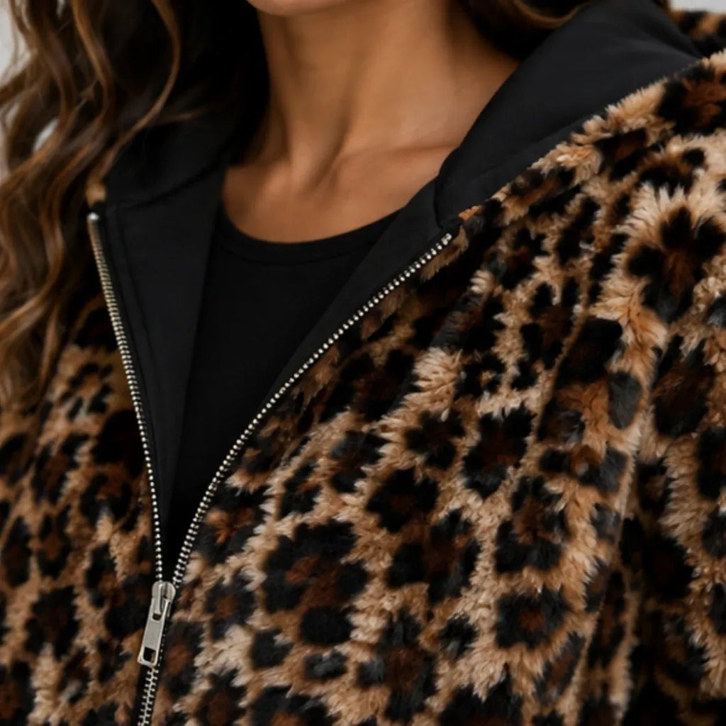 Close-up of leopard print fabric, black hood lining, and zipper on reversible jacket