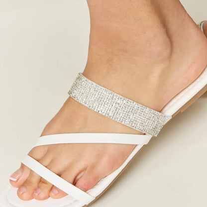 Close-up of the shimmering rhinestone accents on the delicate white straps.