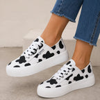 Cow print Roam Wild Convertible Sneakers with white platform soles and lace-up styling.