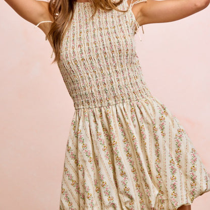 Woman wearing a floral dress against a pink background