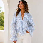 Women's blue floral ruffle chiffon long sleeve blouse featuring cascading layered ruffles, sheer sleeves, lightweight chiffon fabric, and a feminine V-neckline.