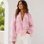 Women's blush pink ruffle chiffon long sleeve blouse with cascading layered ruffles, sheer balloon sleeves, and an elegant flowy fit.
