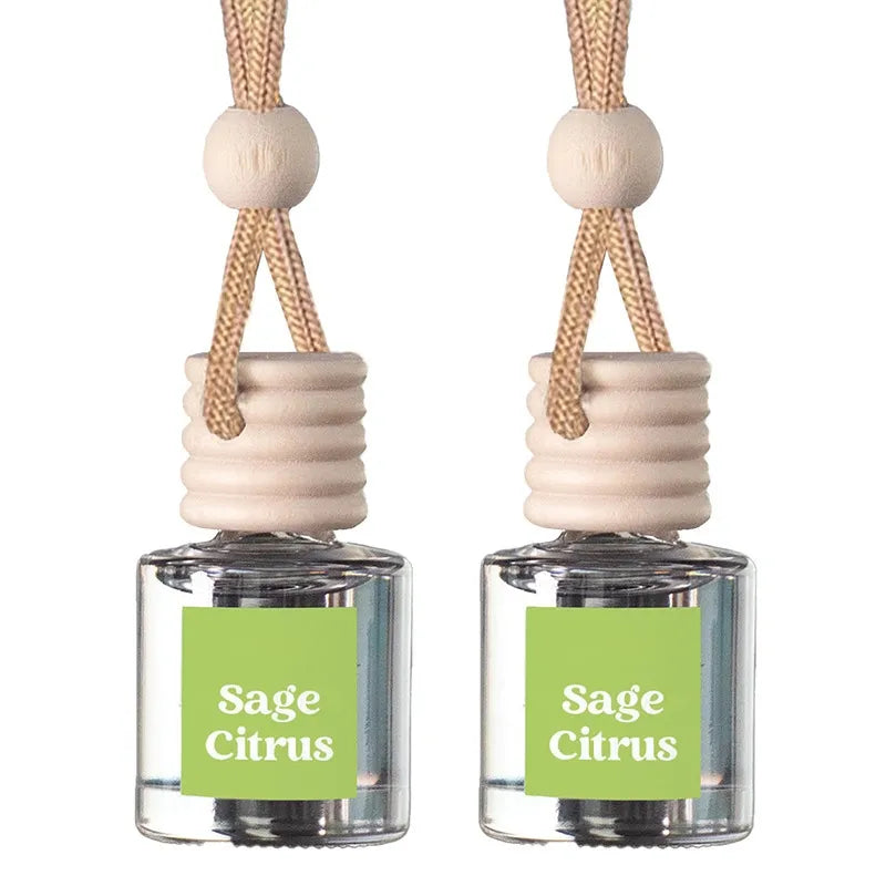 Two reed diffuser bottles with clear glass bodies, light wood stoppers, and natural woven cords, each with a green label reading 'Sage Citrus' on a white background.