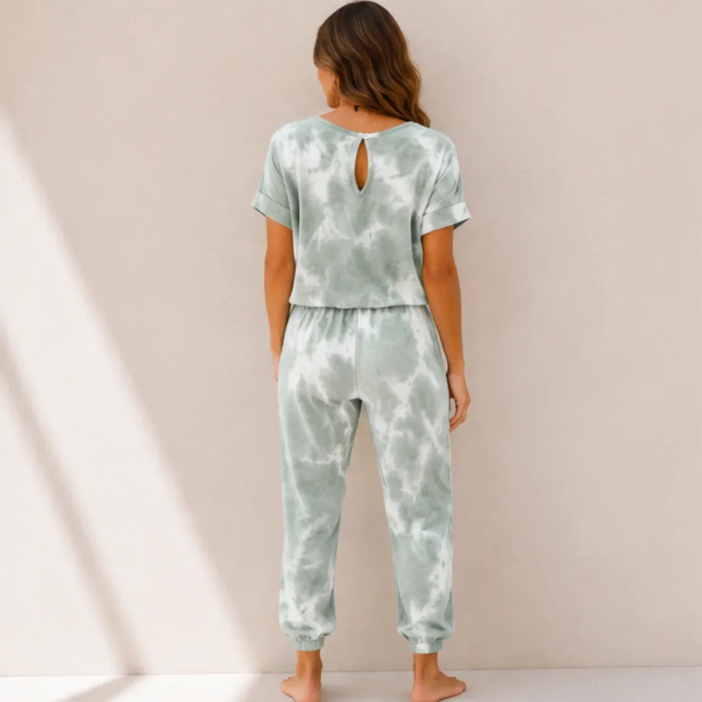 Back view of a women's sage green tie-dye matching loungewear set with short sleeve top and jogger pants.