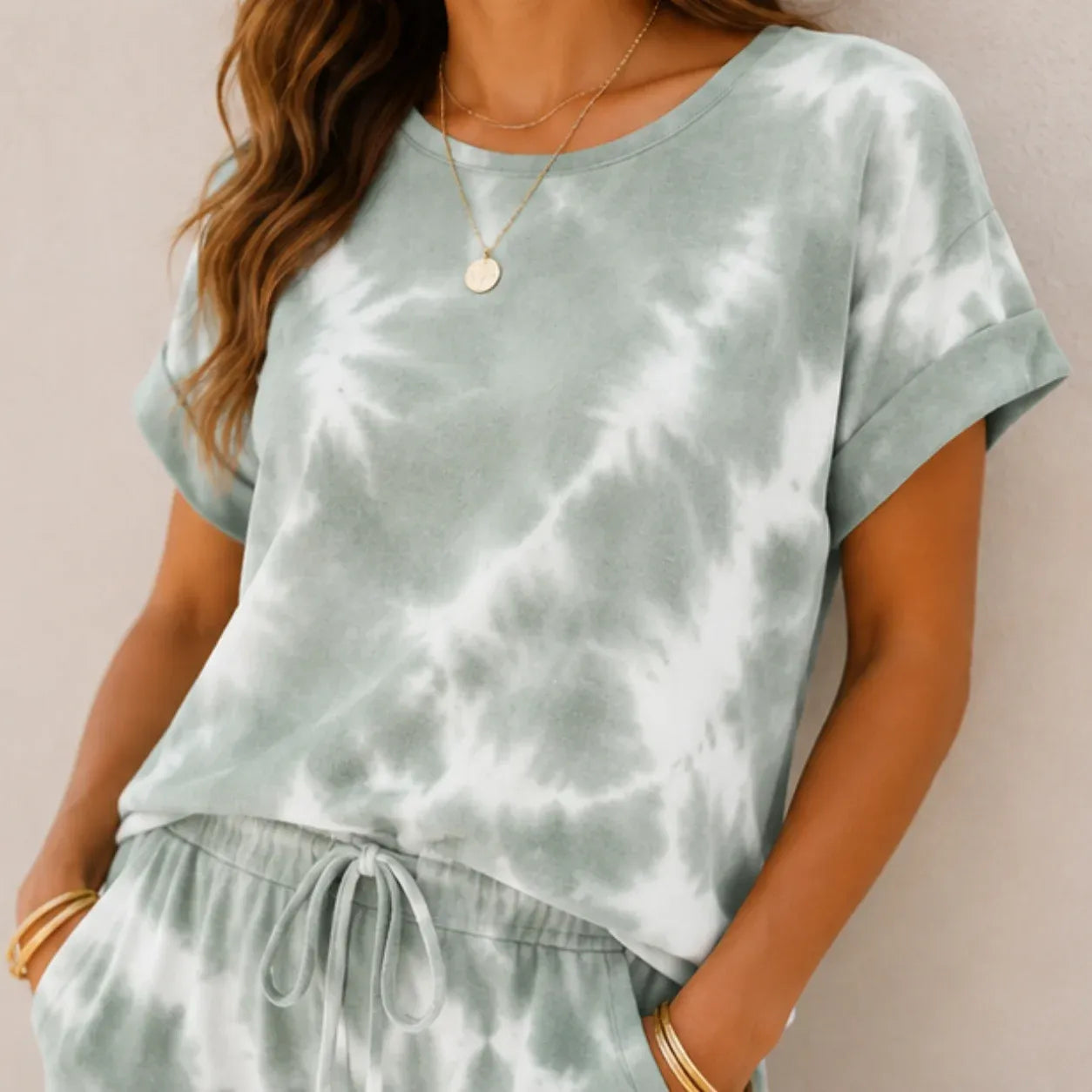 Close-up of the sage green tie-dye short sleeve top and drawstring jogger pants showing the soft fabric and pattern.