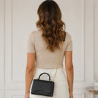 Back view of woman styling the black Shiny Chain Crossbody Bag from Solazura Boutique.