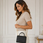 Side view of woman wearing the black Shiny Chain Crossbody Bag with gold chain strap.