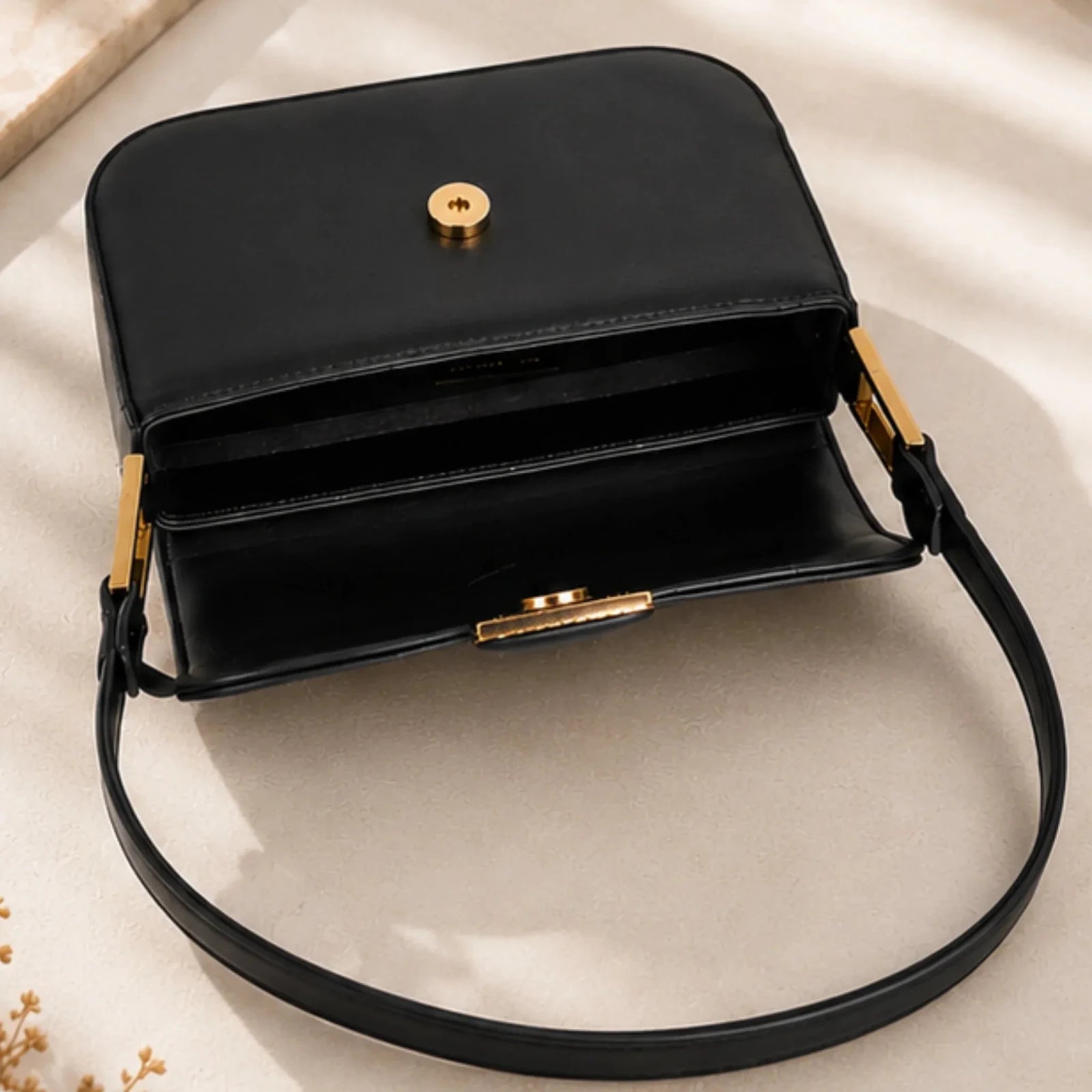 Open black faux leather shoulder bag displaying the spacious interior, magnetic flap closure and premium gold hardware.